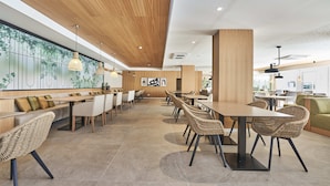 A spacious restaurant with high ceilings, wooden accents, and a long counter with seating. - Hoposa Apartamentos Montelin (Pollenca)