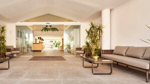A spacious lobby with two sofas, a coffee table, and potted plants. - Hoposa Apartamentos Montelin (Pollenca)