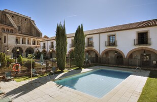 Una piscina al aire libre, sombrillas, sillones reclinables de piscina