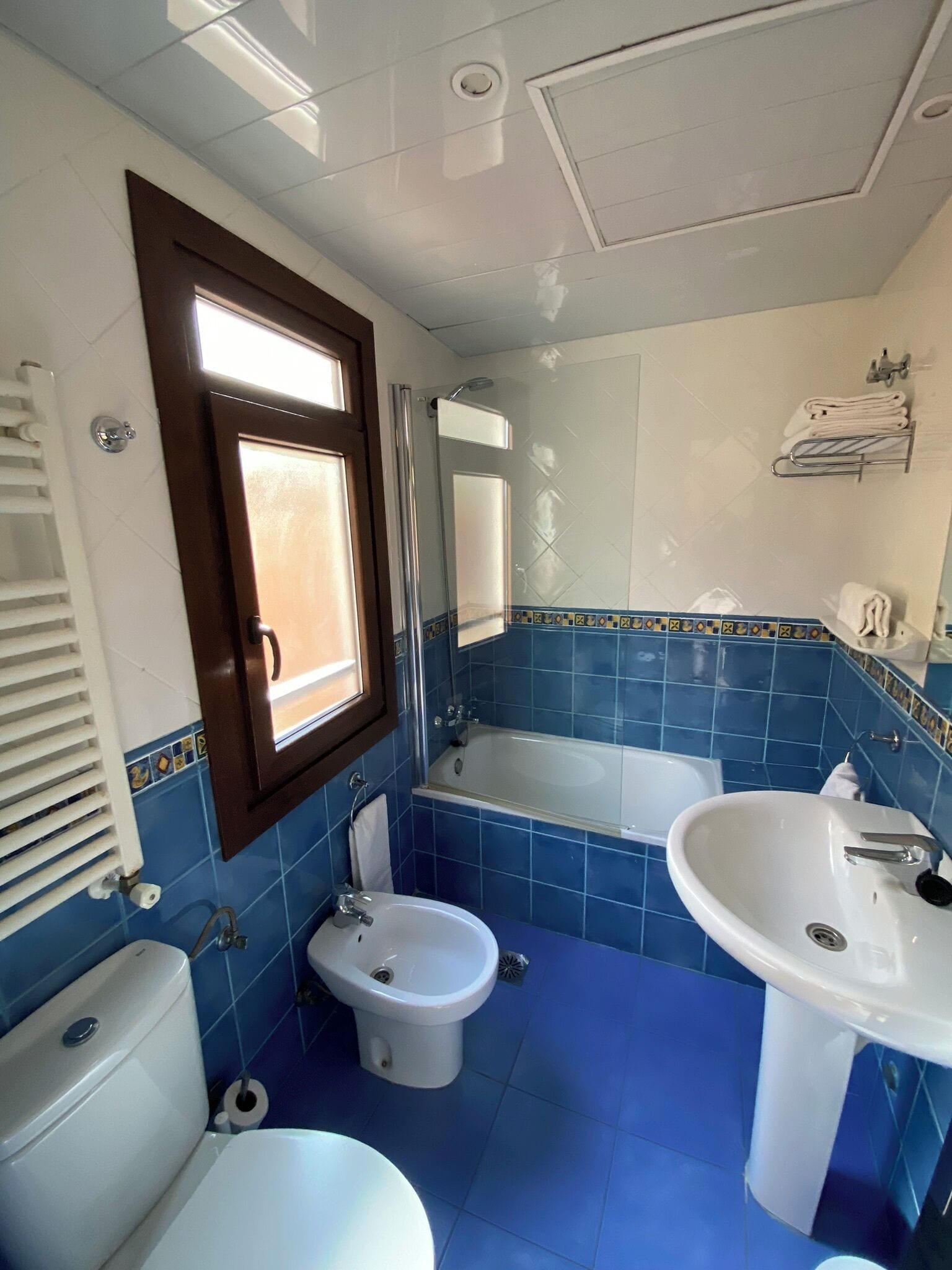 Un baño con inodoro, bidé, bañera y dos lavamanos.
