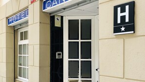 A hotel entrance with a sign reading "CANTON HOTEL" and a black sign with a white 'H' and star.