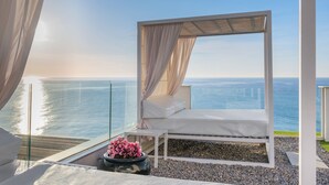 A balcony with a white canopy bed, a small table, and a potted plant. - Hotel Planamar by Escampa Hotels (Castell-Platja d'Aro)