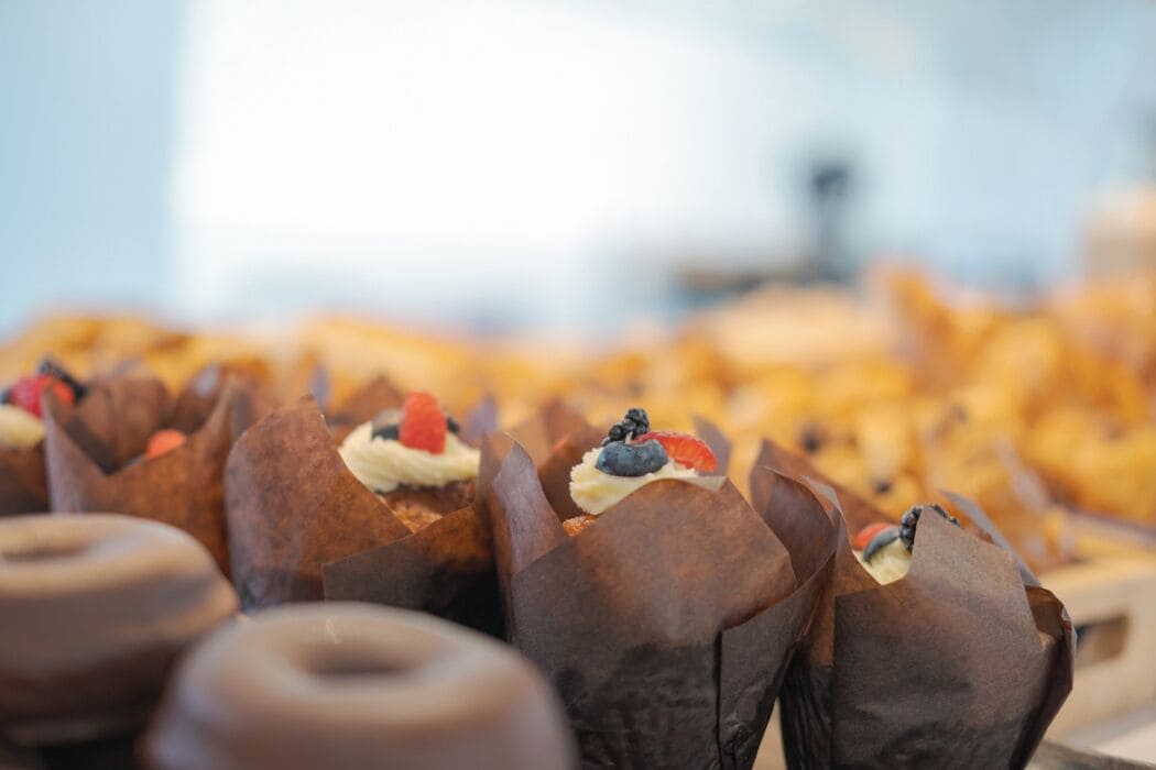 Une présentation de pâtisseries dans des moules en papier, garnies de diverses décorations.