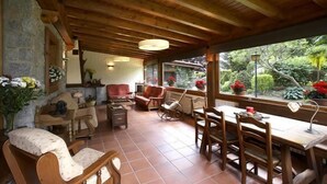 A cozy room with wooden furniture, a stone wall, and a view of greenery outside. - Calitxó (Mollo)