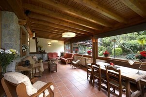 Una habitación acogedora con muebles de madera, una pared de piedra y vistas al exterior.