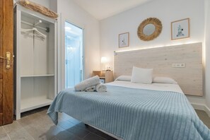 A bedroom with a bed, a wardrobe, and a door to a bathroom.