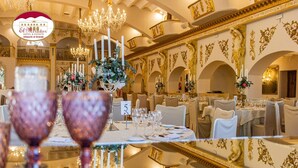 Un espace de restauration luxueux, agrémenté de motifs dorés raffinés, de lustres et d’une décoration de table élégante.