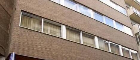 Un edificio de hotel con varios pisos y un letrero que dice "MONCLÚ HOTEL RESIDENCIA".