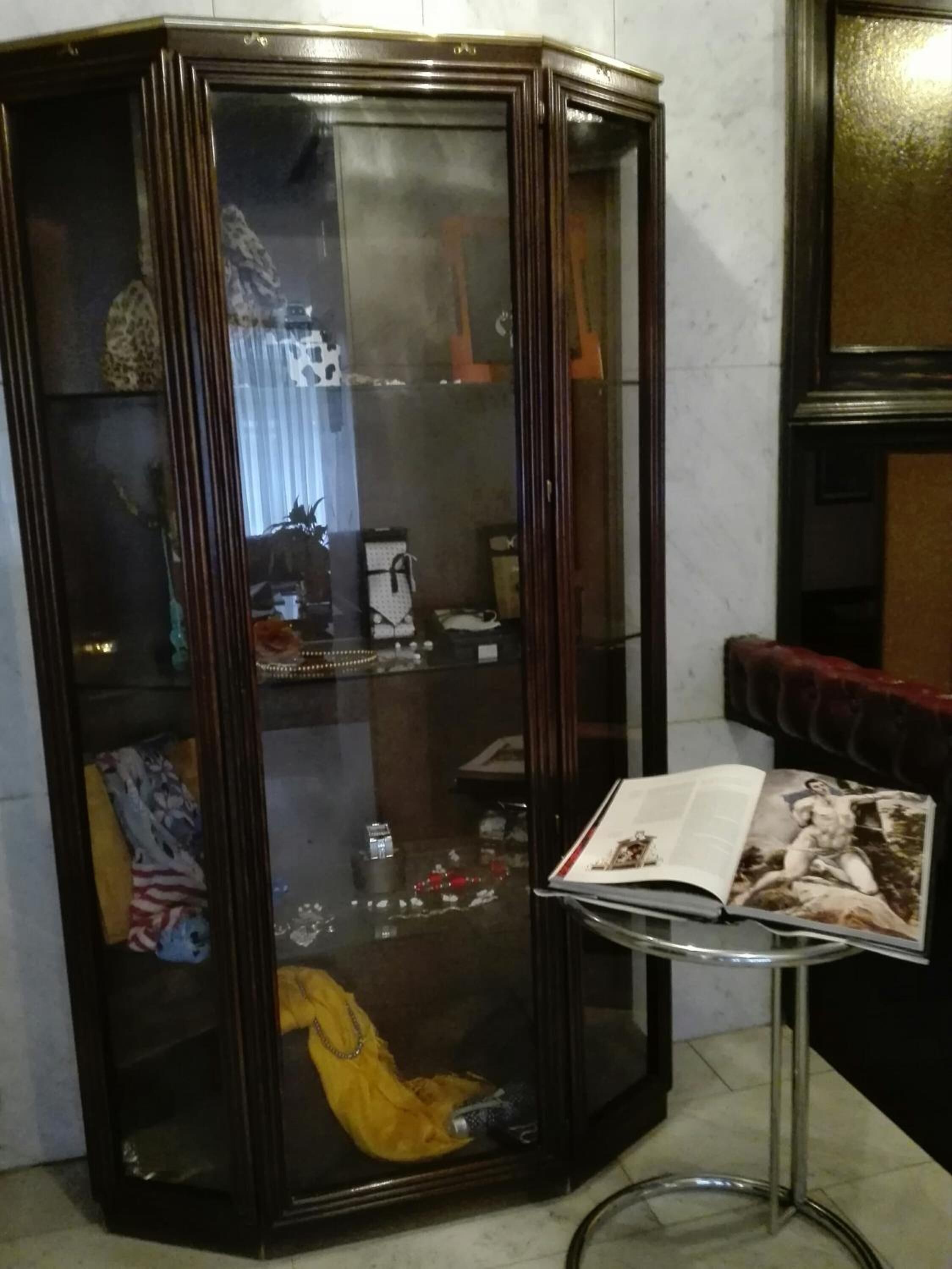 A corner room with a glass display cabinet containing various items.