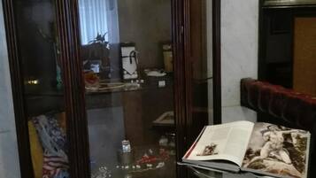 A corner room with a glass display cabinet containing various items.