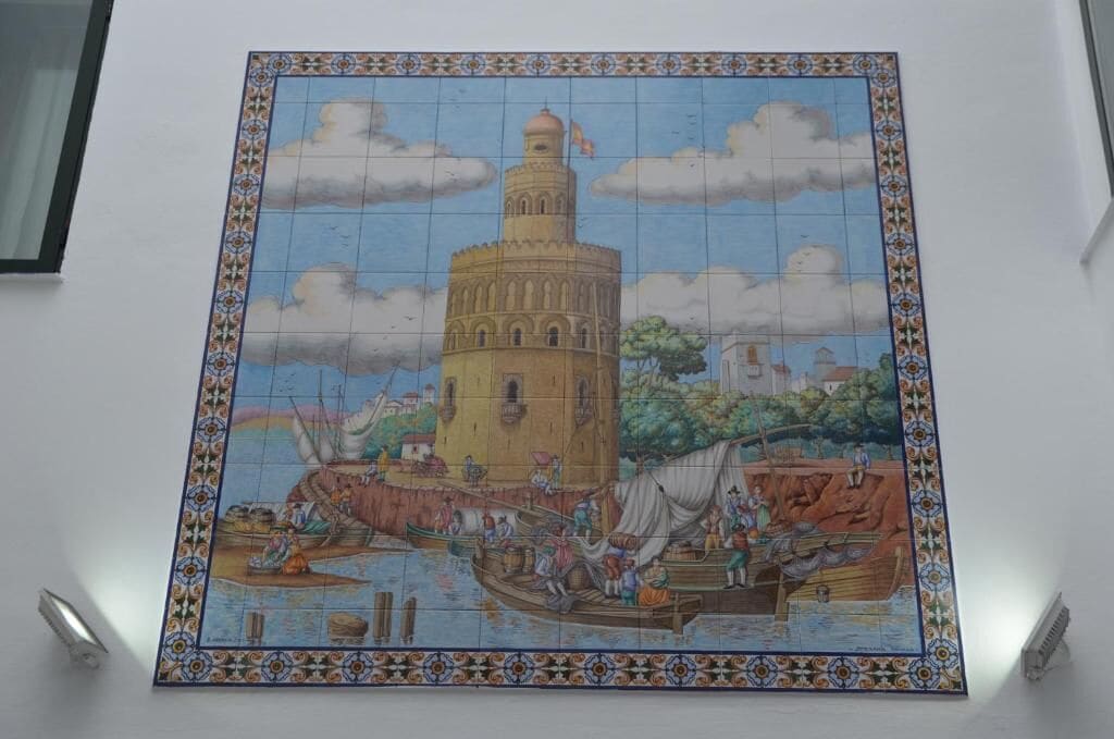 A mosaic tile with a tower and boats.