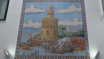 A mosaic tile with a tower and boats.