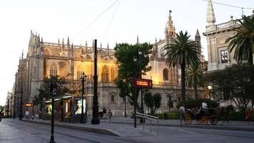 A historic cathedral with intricate architecture, a tram line, and a horse-drawn carriage.
