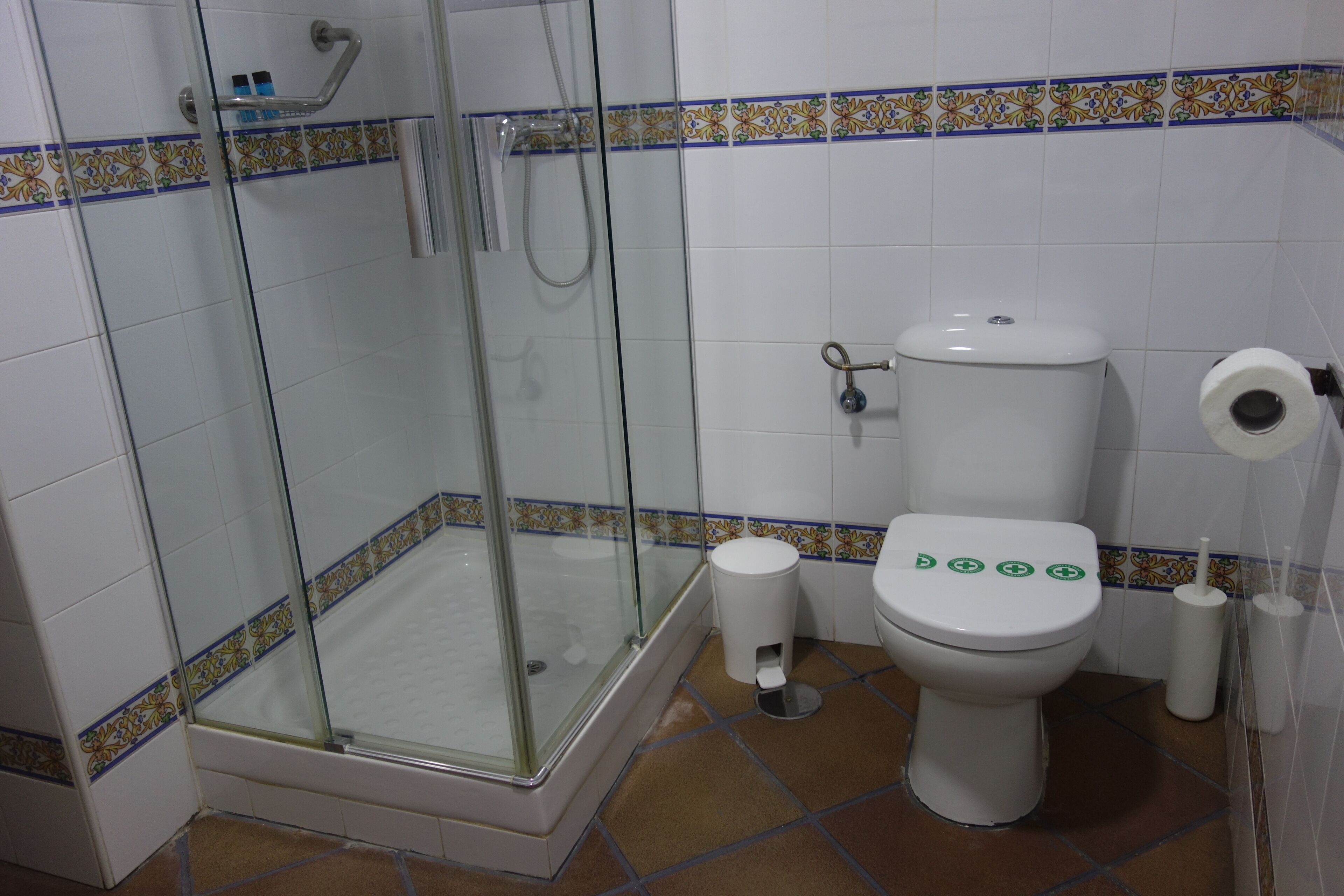 A bathroom with a glass-enclosed shower, a toilet, and a bidet.