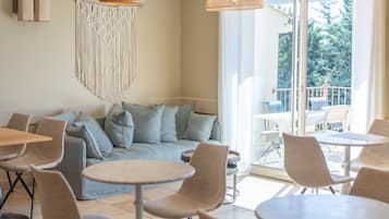 Een modern interieur met een bank, stoelen en tafels voor een diner.