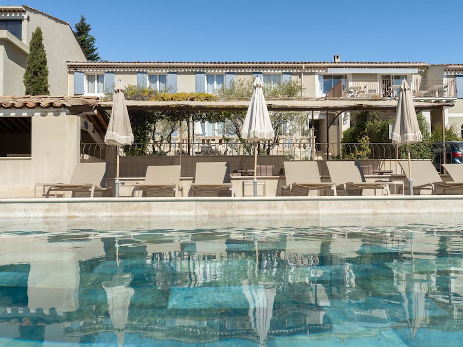 Una piscina al aire libre de temporada, sombrillas