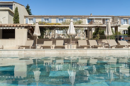 Una piscina al aire libre de temporada, sombrillas