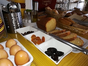 Una mesa de desayuno con pan, huevos y frutas secas.