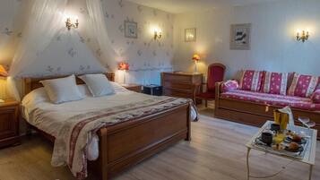 A bedroom with a wooden bed, a red sofa, a nightstand, a dresser, and a bedside table with a lamp.