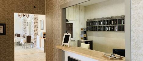 A reception area with a mirror, a chalkboard, and a shelf with keycards.