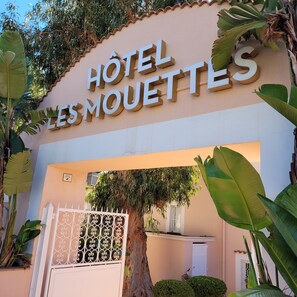 Entrada de hotel con un letrero que dice "HOTEL LES MOUETTES".