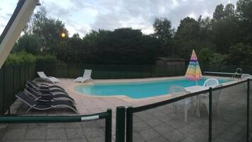 Alberca al aire libre por temporada y sombrillas en la alberca