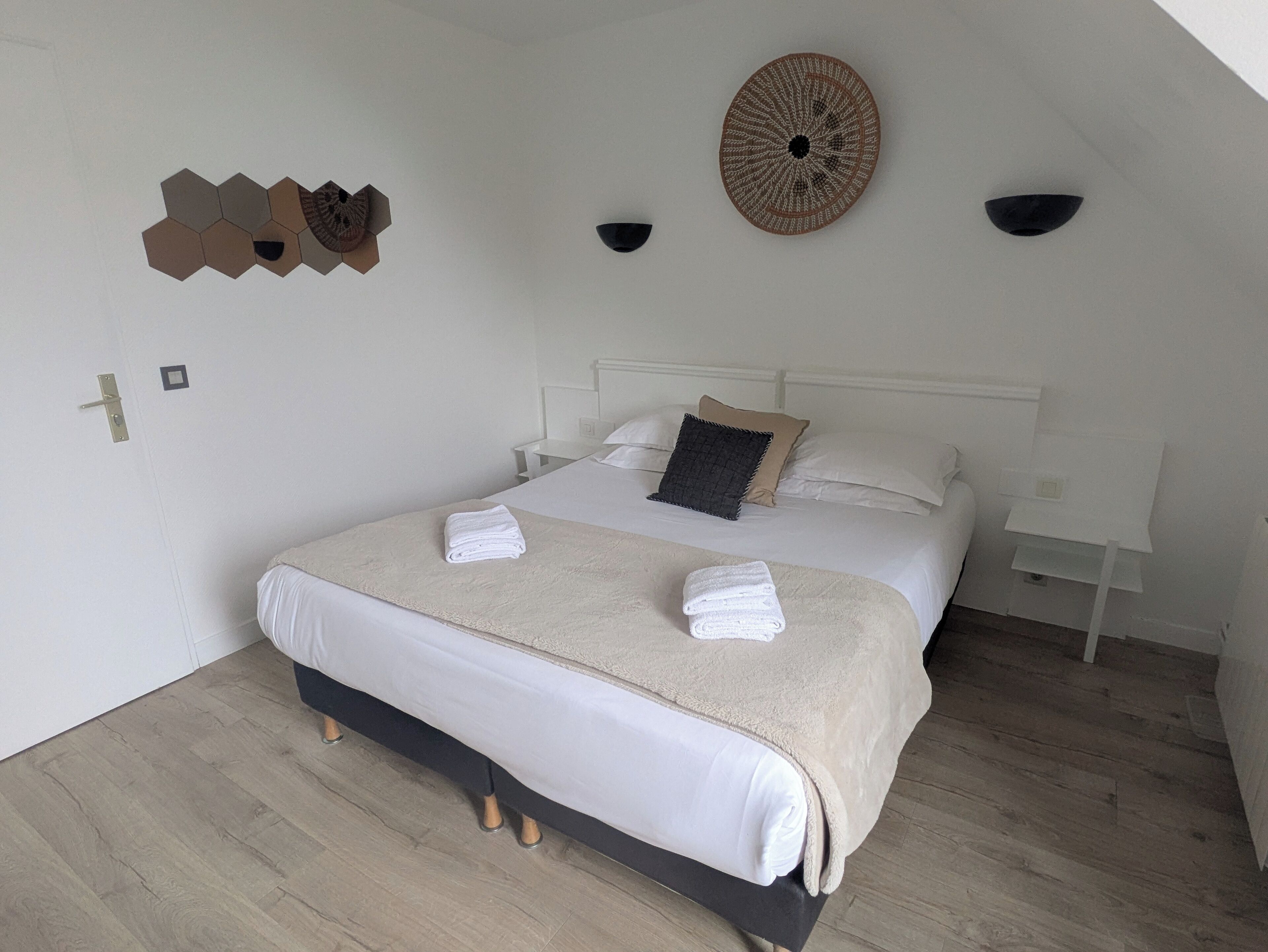 A bedroom with a bed, a wall-mounted decorative item, a ceiling fan, and a light fixture.
