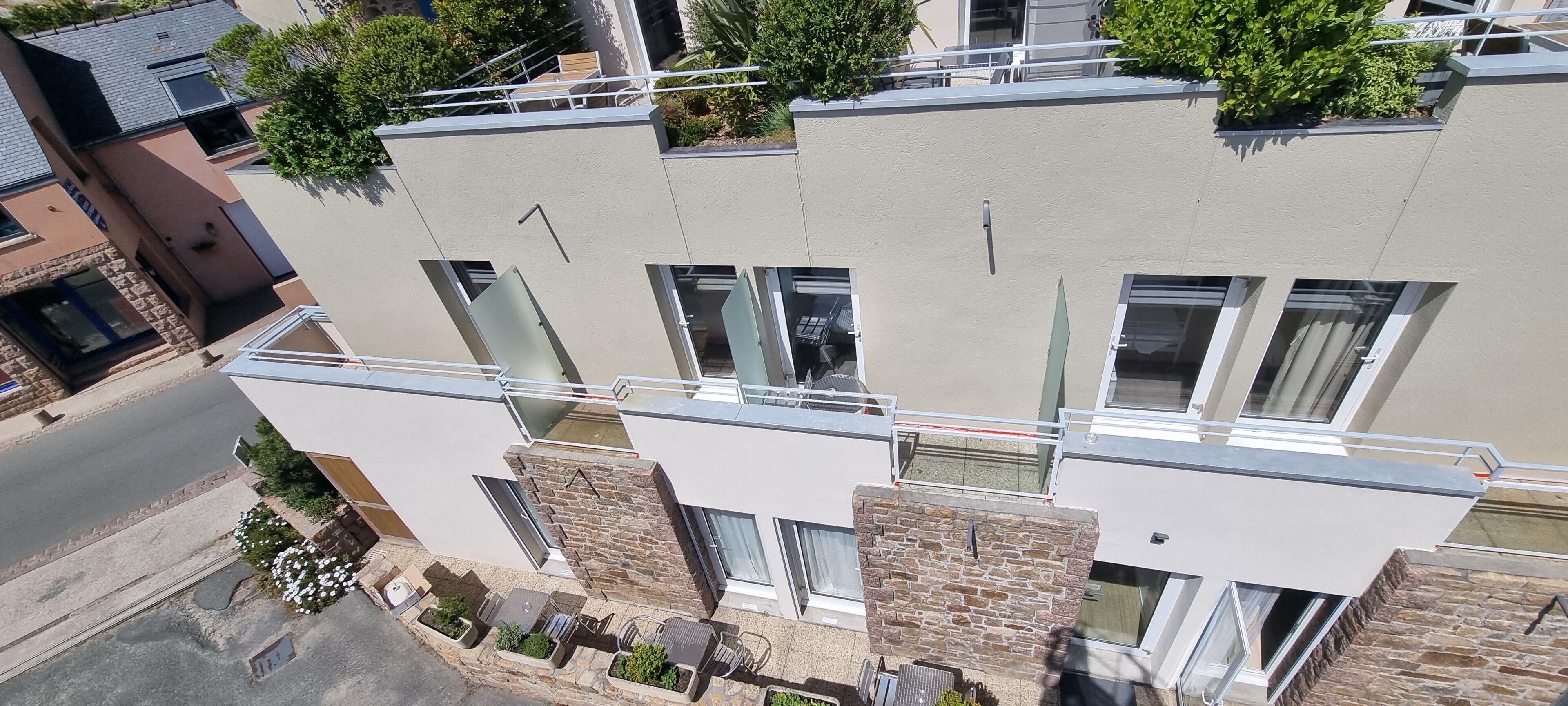 A multi-story building with balconies, large windows, and a mix of brick and stucco exteriors.