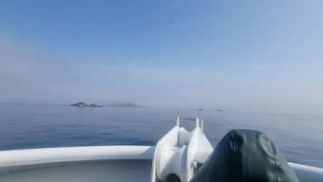 A boat's interior with a view of calm water and distant islands.