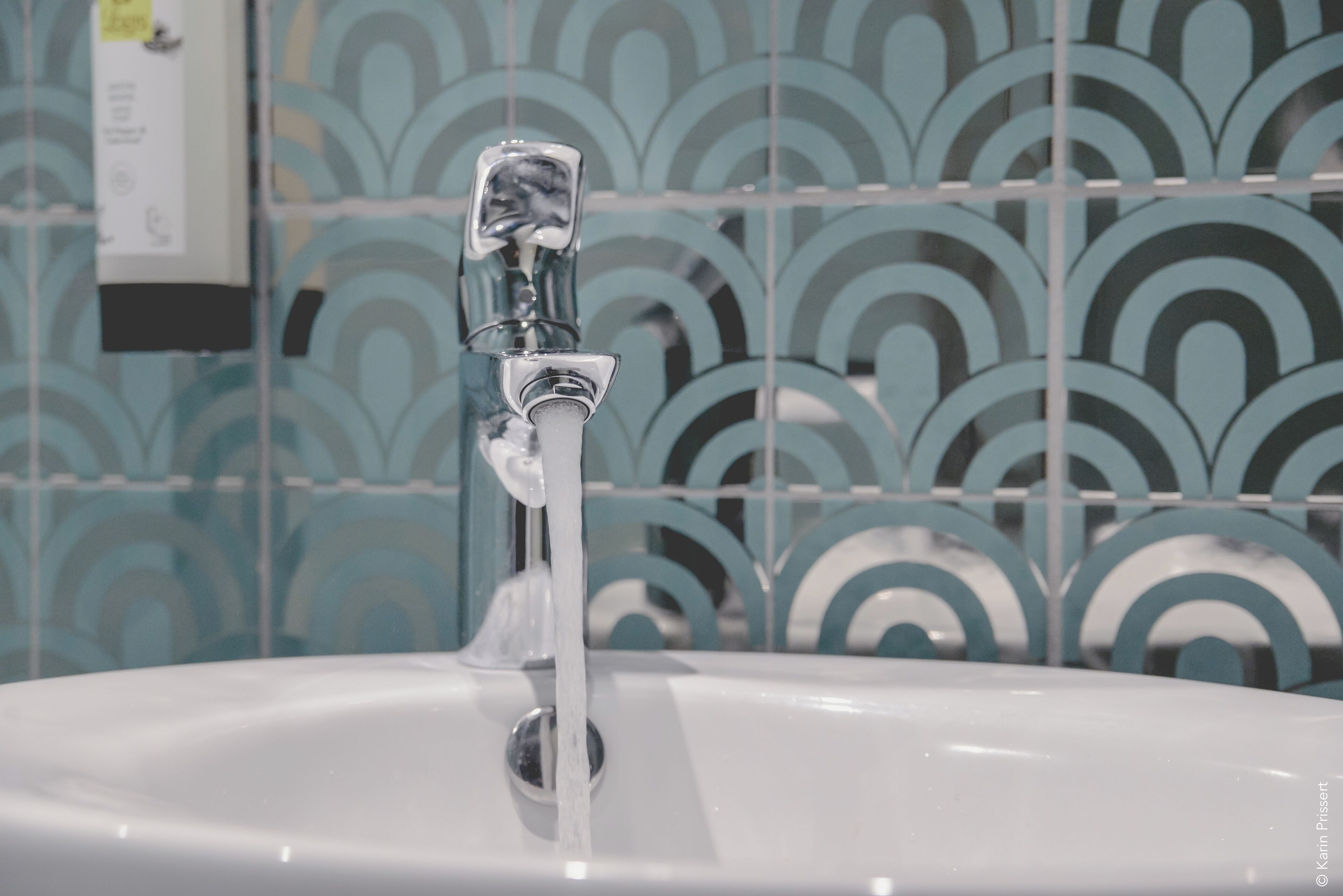 A bathroom sink with a running faucet.