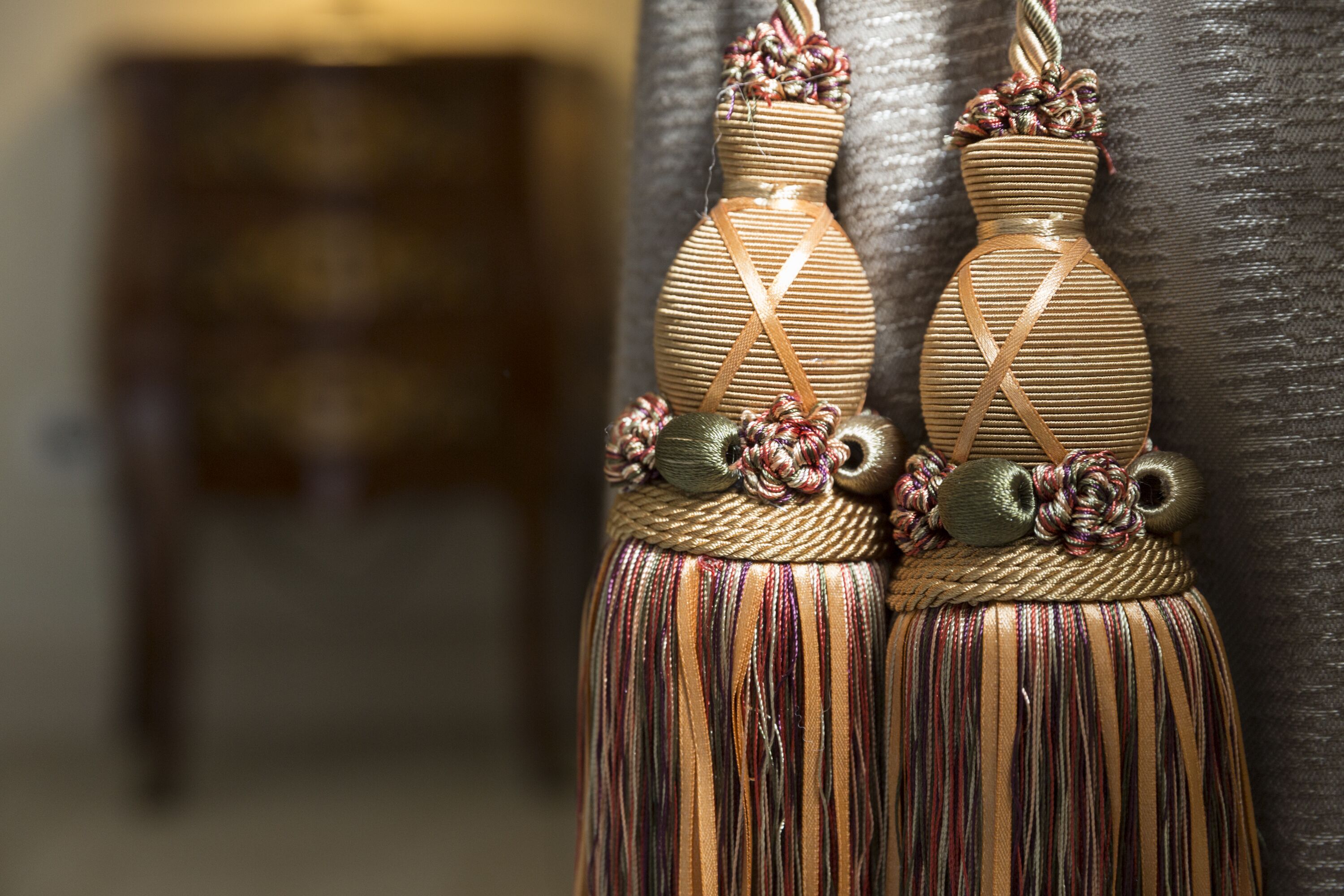 Two decorative vases with tassels and floral designs.