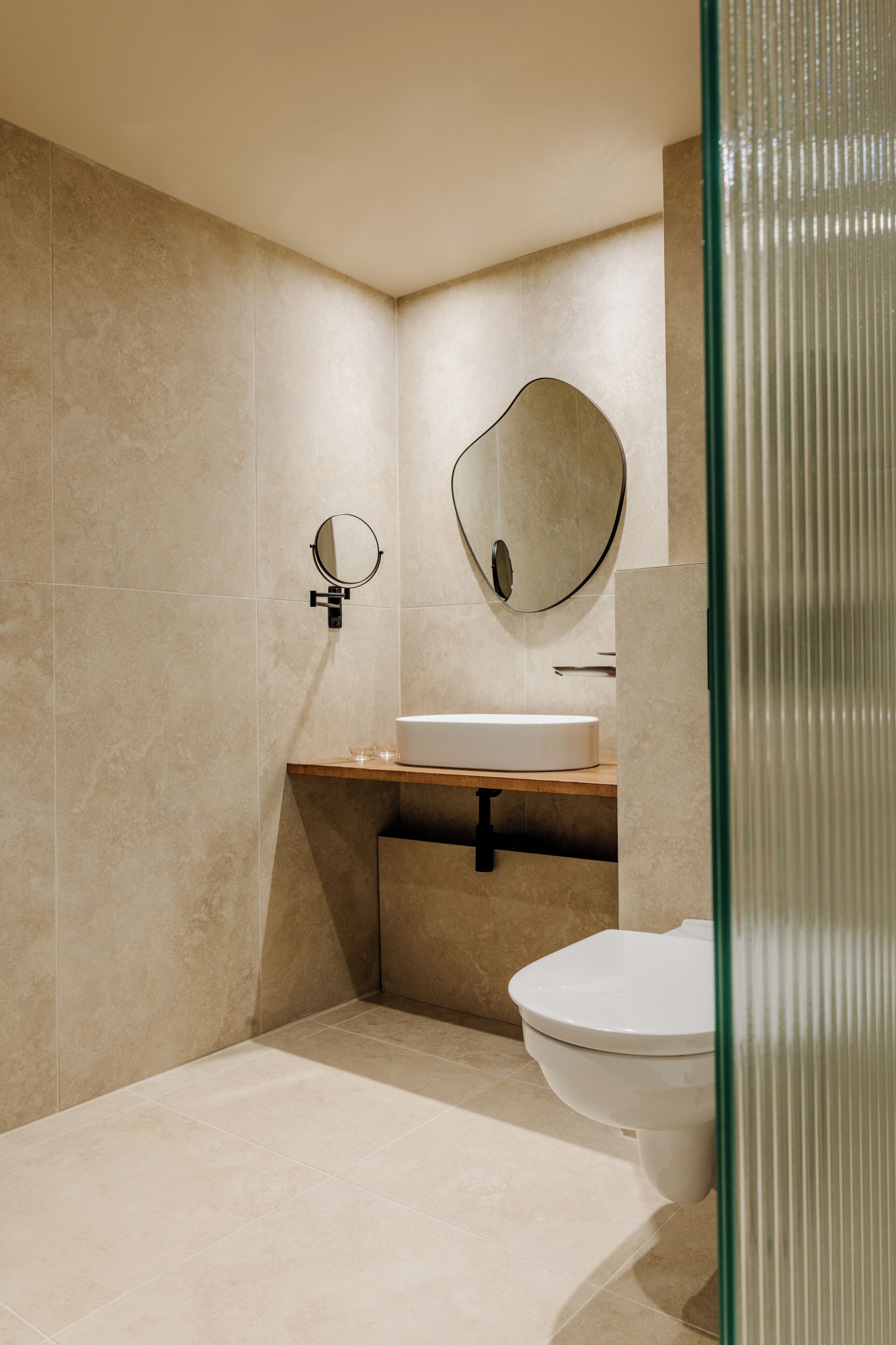 A modern bathroom with a toilet, sink, and mirror.