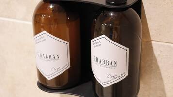Dos botellas de champú Chabran sobre un jabonero negro.