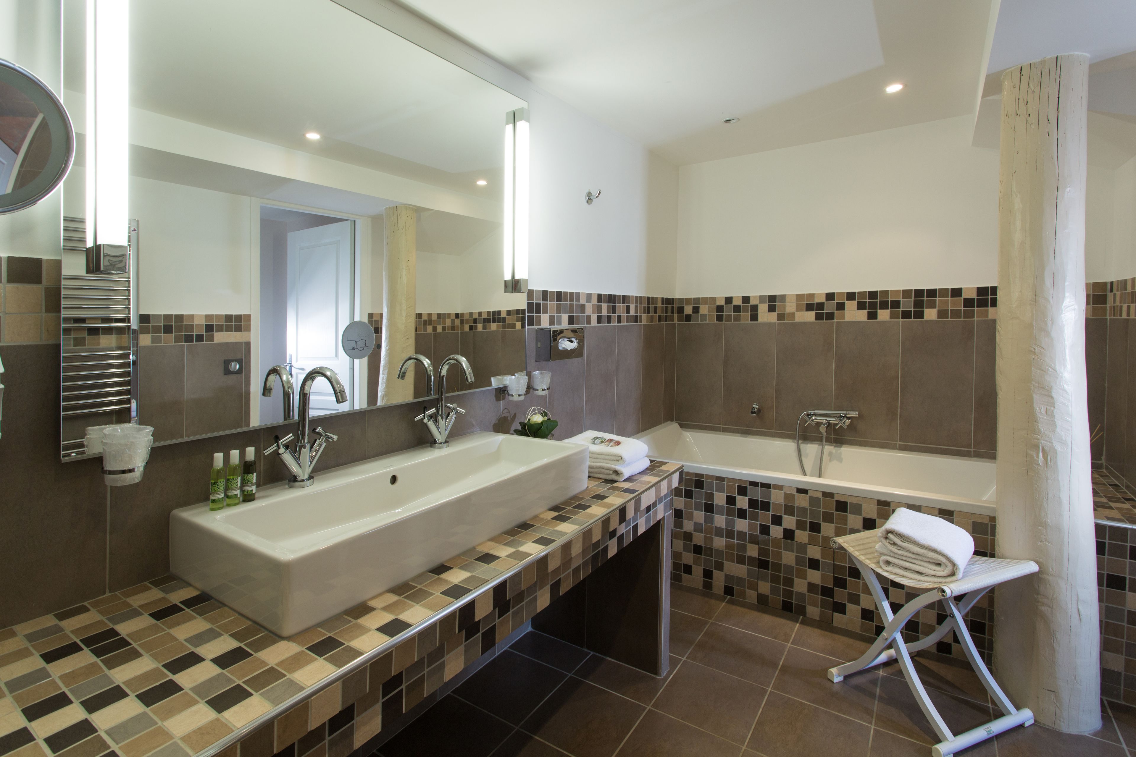 A modern bathroom with a large sink, a bathtub, and a shower.