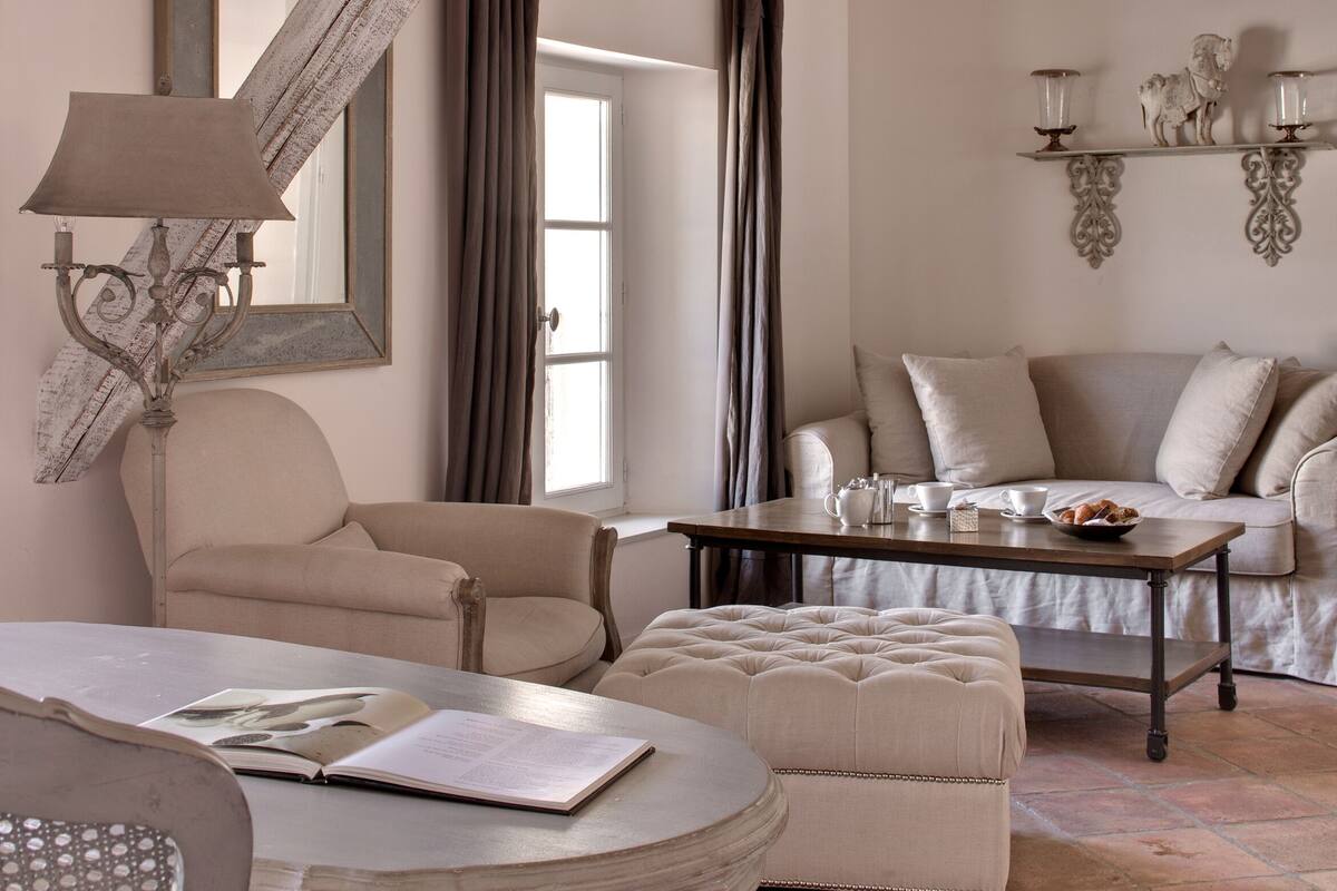 A living room with a sofa, armchairs, a coffee table, and a lamp.