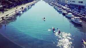 Un canal bordé de bateaux et d’immeubles, un ciel dégagé et une tour qui se profile à l’horizon.