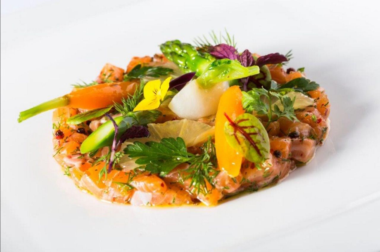 Un plat composé de divers légumes et herbes aromatiques, servi dans une assiette blanche.