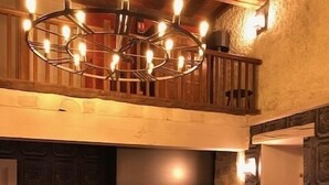 A cozy living room with a fireplace, comfortable seating, and a modern chandelier. - Castel Damandre (Les Planches-pres-Arbois)
