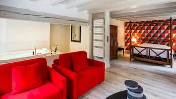 A modern room with a red sofa, a wooden bed frame, and a geometric patterned wall.
