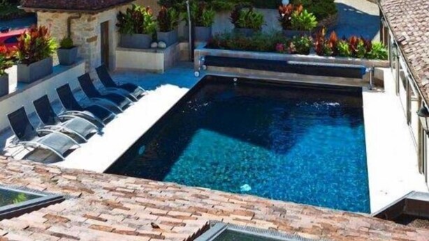 A two-story building with a pool and outdoor seating. - Castel Damandre (Les Planches-pres-Arbois)