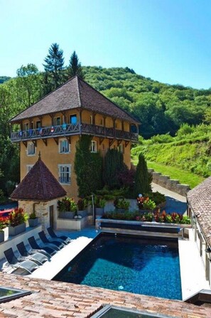 Un edificio de dos pisos con piscina y zona de estar al aire libre.