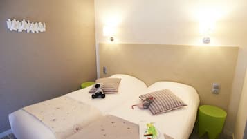A hotel room with two beds, a green nightstand, and a wall-mounted light fixture.
