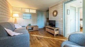 A modern living room with a sofa, TV stand, and wooden floors.