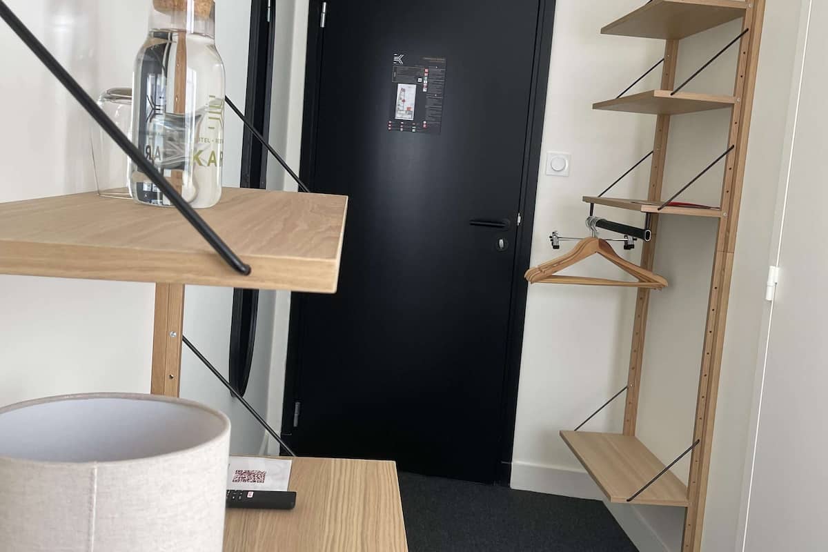 Una habitación con un escritorio de madera, una lámpara, una silla verde y una puerta negra con un mapa.
