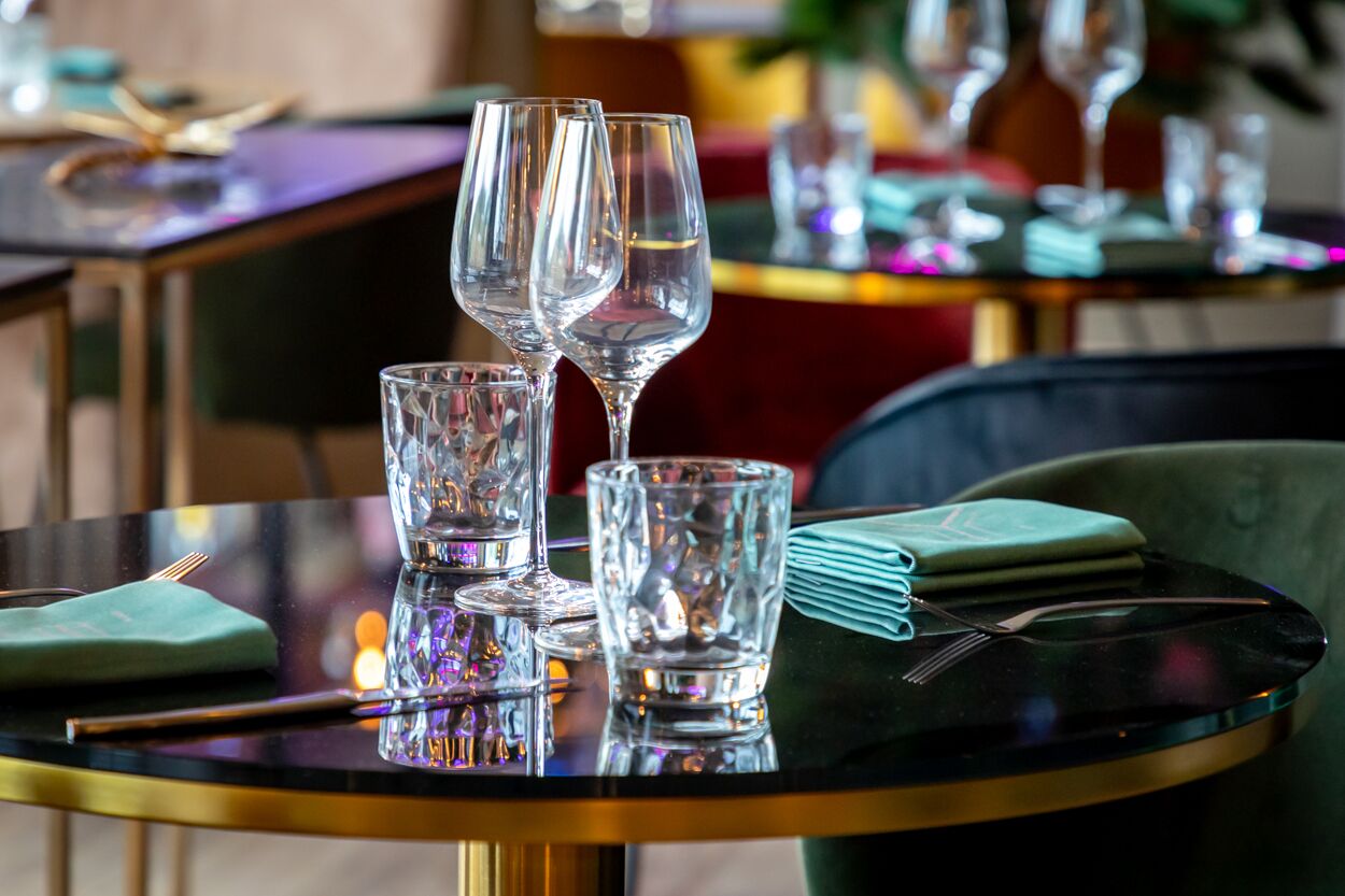 Une table à manger avec trois verres à vin et une serviette pliée.