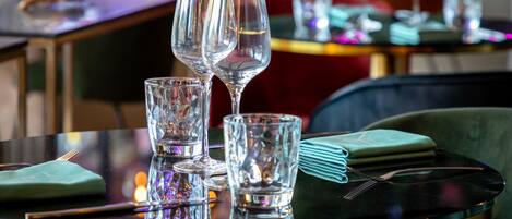 Une table à manger avec trois verres à vin et une serviette pliée.