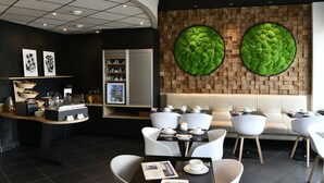 A modern cafe with a counter, seating area, and decorative wall panels.