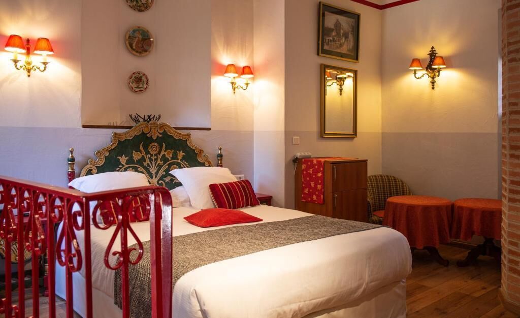 Ein Hotelzimmer mit einem Bett, zwei Nachttischen, einem Kleiderschrank und zwei kleinen runden Tischen.