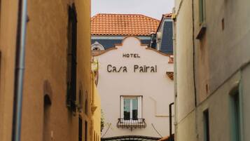 A narrow alleyway leading to a building with a sign reading 'HOTEL CASA PAIRAL.'