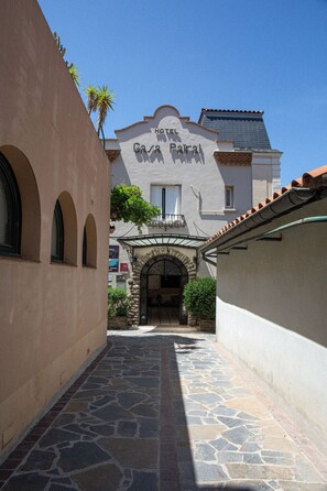 A narrow stone-paved alley leading to a building with a sign reading "Hotel Casa Palmar."